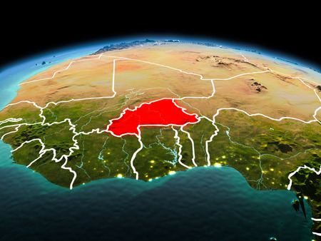 Morning above Burkina Faso highlighted in red on model of planet Earth in space with visible border lines and city lights. 3D illustration.の写真素材
