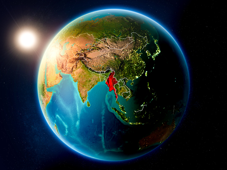 Sunset above Myanmar highlighted in red on planet Earth with visible country borders. 3D illustration.の写真素材