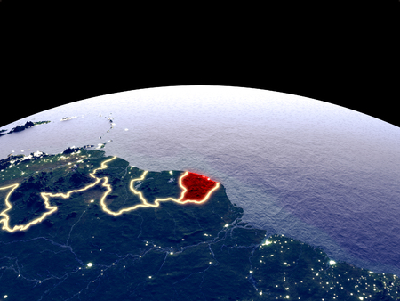 French Guiana from space on planet Earth at night with bright city lights. Detailed plastic planet surface with real mountains. 3D illustration.の写真素材