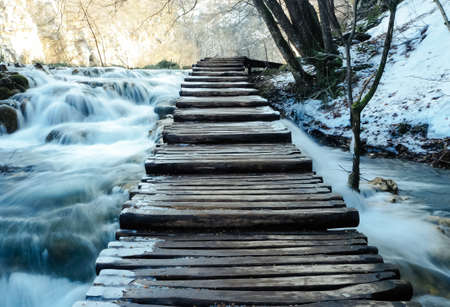 Wooden Foot Bridge over waterfalls.の写真素材