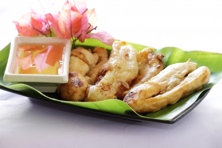 fried banana with honey sauce served on a banana leafの写真素材