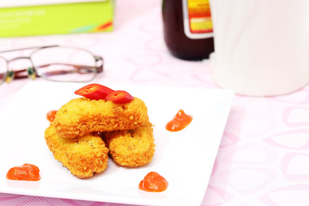 chicken nuggets with sauce served on a plateの写真素材