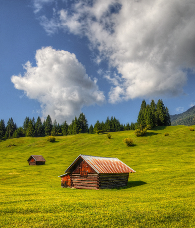 Wooden barns located on a hill in the middle of the Alpsの写真素材
