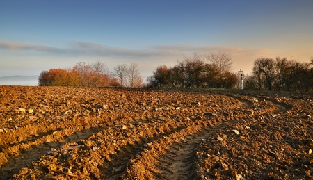 autumn scene with freshly plowed field and calvary