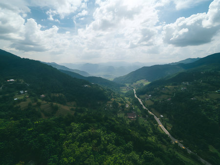 Aerial view of beautiful mountain landscape with green forest and blue skyの素材