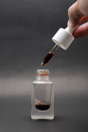 Close-up view of isolated serum in a glass bottle with a Black backgroundの写真素材