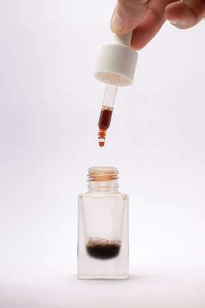 Close-up view of isolated serum in a glass bottle with a white backgroundの写真素材