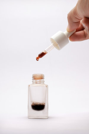 Close-up view of isolated serum in a glass bottle with a white backgroundの写真素材