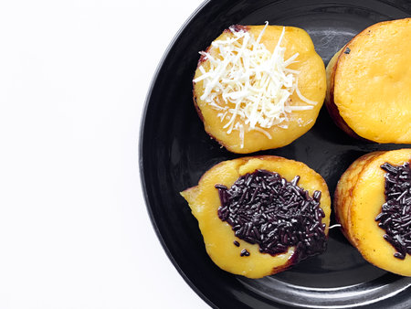 Close-up Sponge Cake, Kue lumpur with cheese and chocolate toppings. on a black plate isolated on white backgroundの写真素材