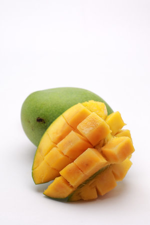 Fresh Mango with Cubed Mango Pieces on White Background, Vibrant Tropical Fruit Still Lifeの写真素材