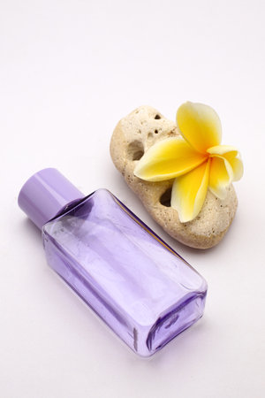 Elegant Perfume Bottle with Yellow Plumeria Flowers on White Background for Spa and Beautyの写真素材