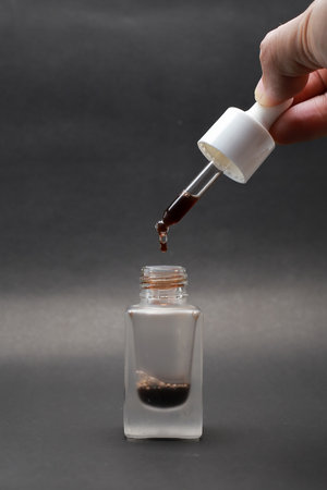 Close-up view of isolated serum in a glass bottle with a Black backgroundの写真素材