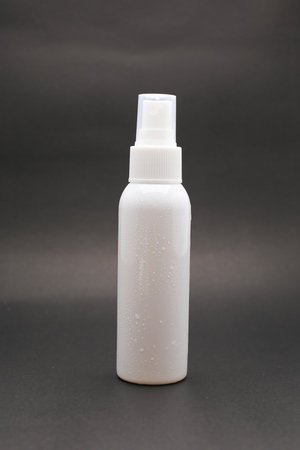 Isolated White Spray Bottle Against a Bright Yellow Background with Water Droplets.の写真素材