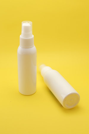 Isolated White Spray Bottle Against a Bright Yellow Background.の写真素材