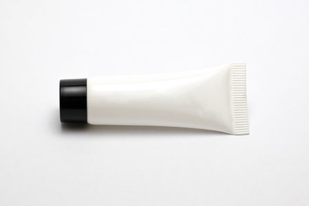 Isolated White Plastic Tube with Black Cap on a Clean White Background. Perfect for graphic design and branding purposes.の写真素材