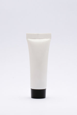 Isolated White Plastic Tube with Black Cap on a Clean White Background. Perfect for graphic design and branding purposes.の写真素材