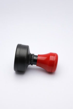 Red and Black Rubber Stamp on White Surface Close-Up. showcasing its compact design and functionality.の写真素材