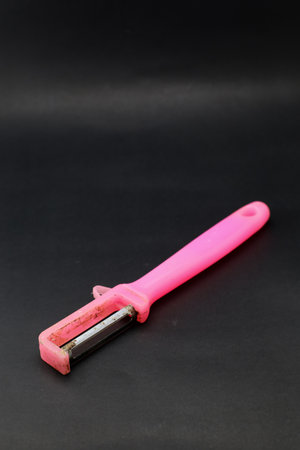 Plastic vegetable peeler with a knife on a black backgroundの写真素材