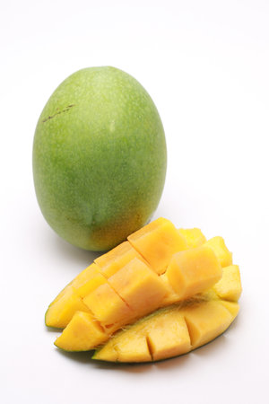 Fresh Mango with Cubed Mango Pieces on White Background, Vibrant Tropical Fruit Still Lifeの写真素材