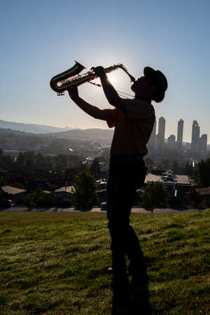 A picture of a man playing alto sax against the sunlight.   Vancouver BC Canadaの写真素材