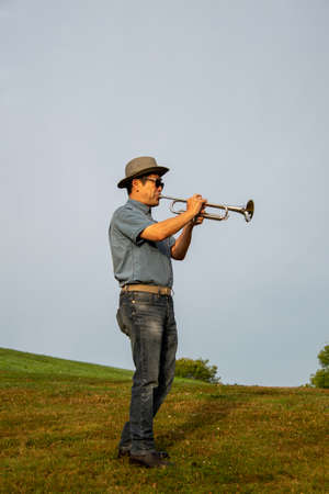 A man playing the trumpet at a park.   Vancouver BC Canada