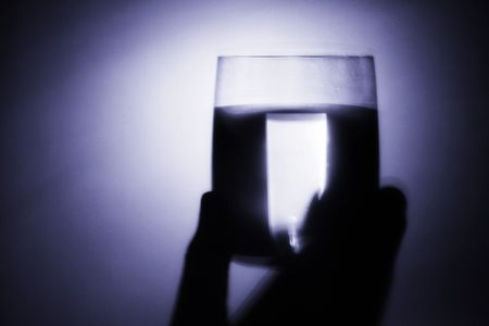 the hand is holding a glass of waterの写真素材