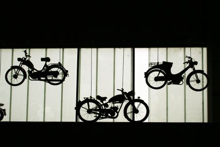 silhouettes of old motorbikes on the wallの写真素材