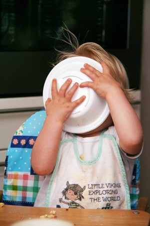 Little baby is licking the plate cleanの写真素材