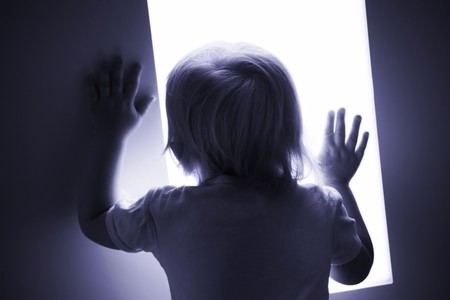 little baby is looking out of the windowの写真素材