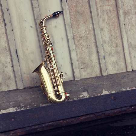 old grungy saxophone with old retro backgroundの写真素材