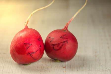 Two radish heads with painted smilesの写真素材