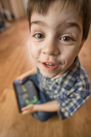 The boy with the tablet was very surprised at what he saw. Strong surprise. Optical distortion of...