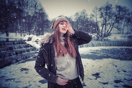 Model posing girl posing against a background of winter nature. Dressed for winter beautiful appearance, long hairの写真素材