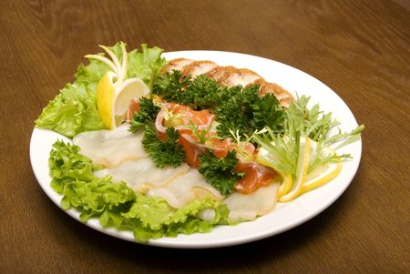 Appetizer made of meat and fish served with salad on the round plateの写真素材