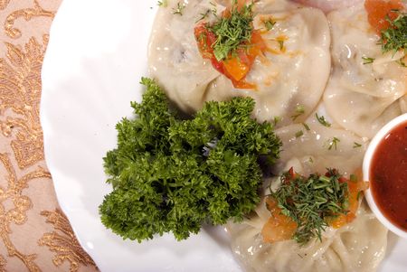 Dough stuffed with minced meat and served with sauce の写真素材