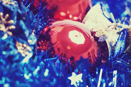 Red Christmas balls with blue tinsel and silver bell close-upの写真素材