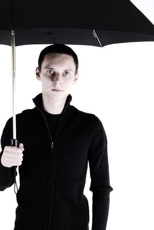 Portrait of a young dark-haired man standing  under umbrellaの写真素材