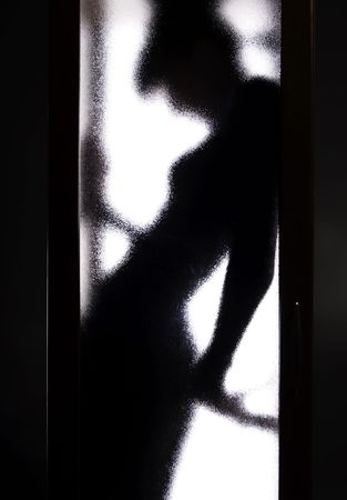 blackl silhouette of the girl behind the glass doorの写真素材
