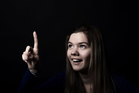 Portrait of a young beautiful girl pointing at somethingの写真素材