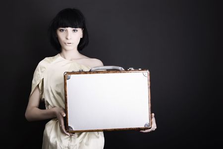 A beautiful brunette posing with suitcase の写真素材