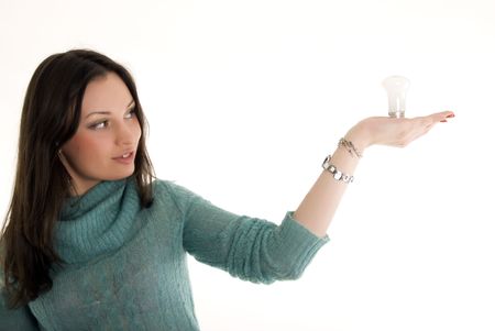 Portrait of a young beautiful brunette holding a  bulb symbolizing an idea or innovationの写真素材