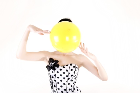 Portrait of a young beautiful brunette posing with yellow ballの写真素材