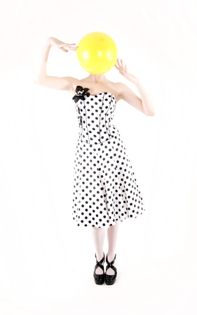 Portrait of a young beautiful brunette posing with yellow ballの写真素材