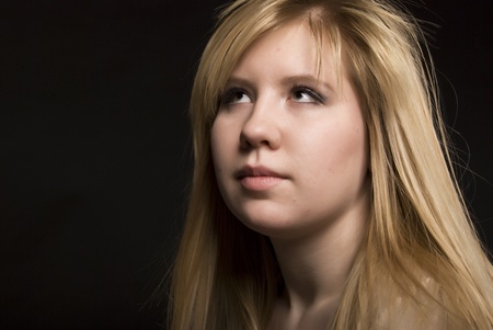 Portrait of a young beautiful blonde over blackの写真素材