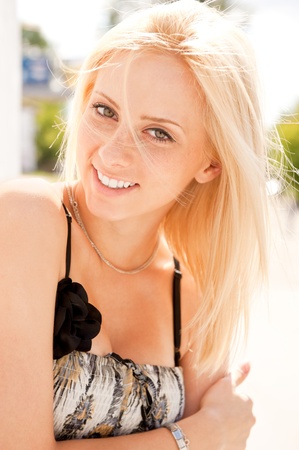 Closeup portrait shot of a young, beautiful, blond, fashionable woman outdoor leaning on the wallの写真素材
