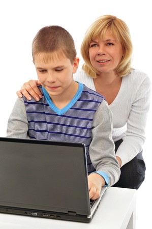 Portrait of adult woman watching as her son doing homework using his laptop and fast wireless internet. Copyspace. Isolated on white backgroundの写真素材