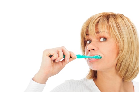 Detail portrait of a happy and wondered mature woman brushing her teeth isolated on white background with copyspaceの写真素材
