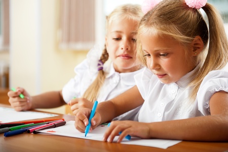 Little girls drawing pictures and writing letters to Santa Claus to get christmas gifts. Indoor at classroomの写真素材