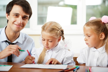 Teacher helping elementary school pupils with their tasksの写真素材