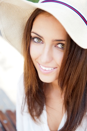Beautiful young elegant woman wearing hat outdoor at park she is relaxed and daydreamingの写真素材